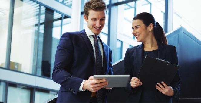 Man and woman looking at documents on tablet.