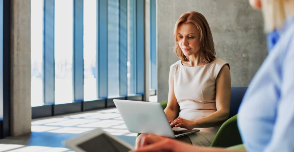 Featured Image For On Demand Webinars with a woman typing on her laptop.